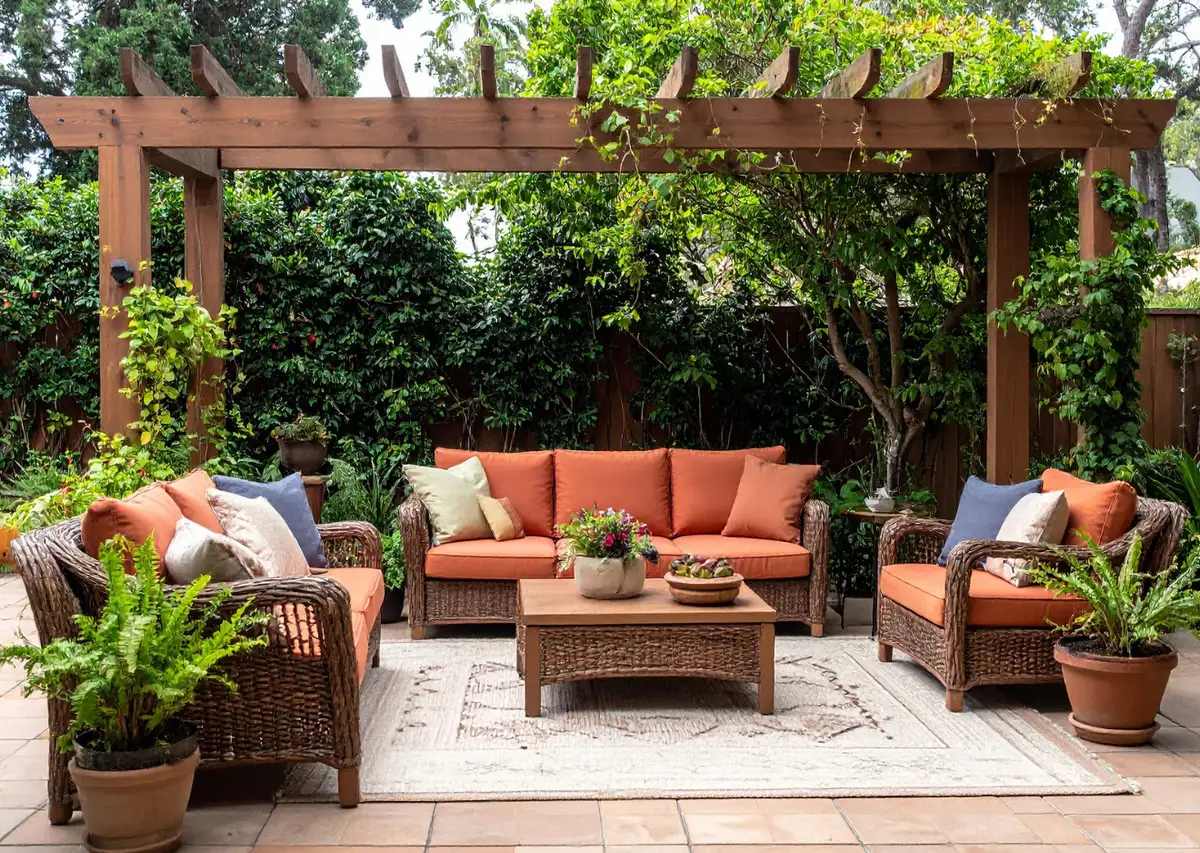 Timber-framed pergola over a paver patio with wicker lounge seating and climbing vines